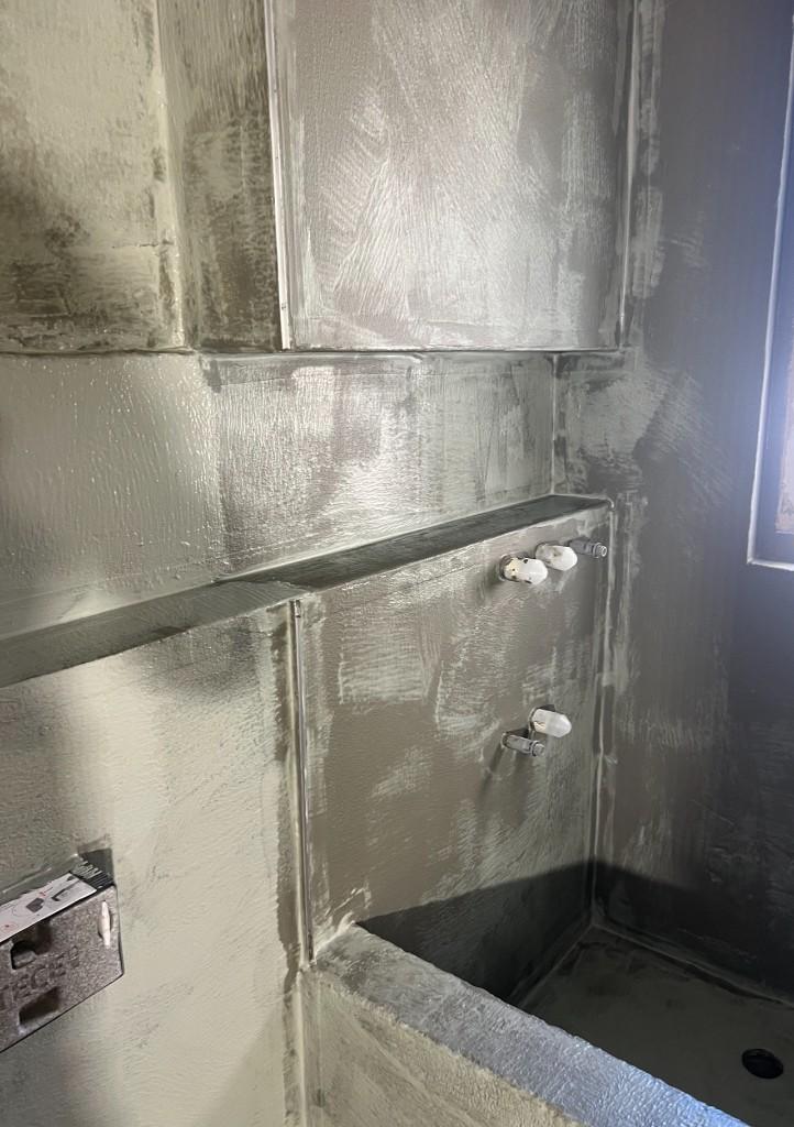 Bathroom walls and floor fully coated with grey waterproofing membrane