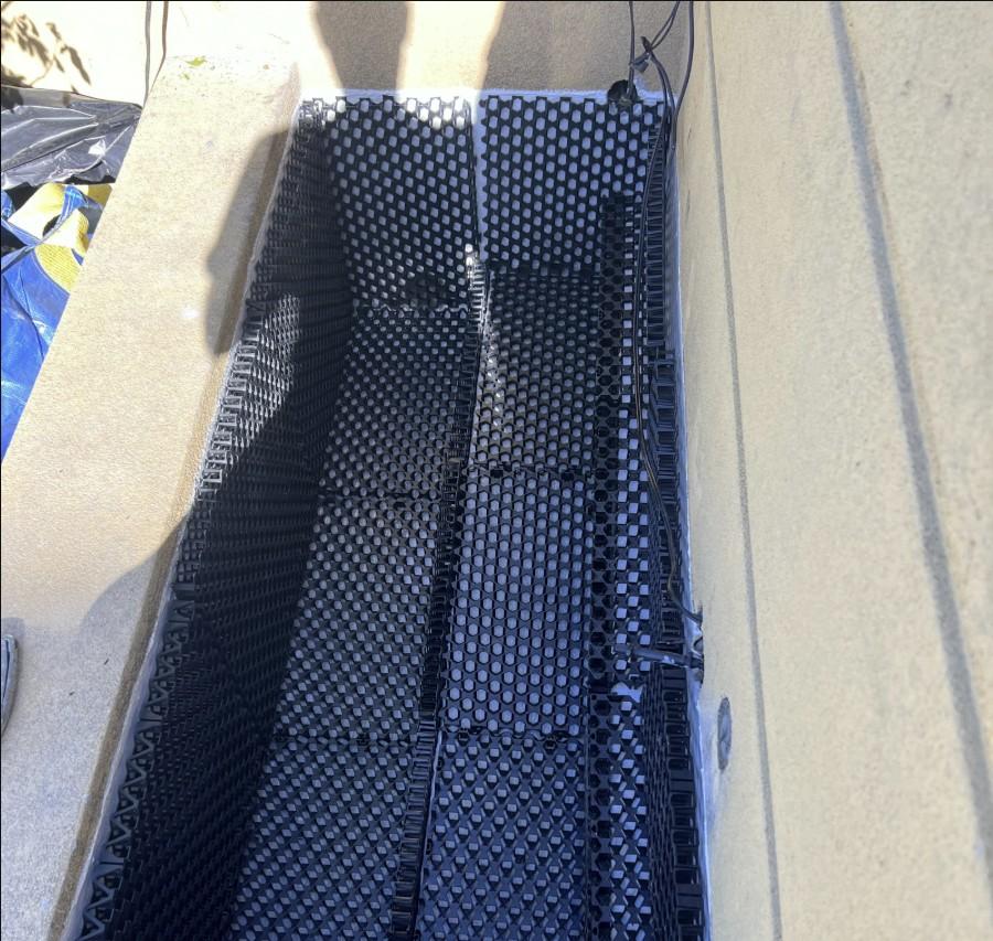 Drainage cell installed over waterproofing membrane in planter box