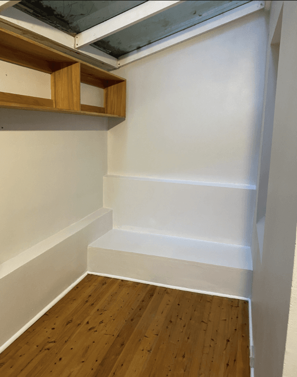 Finished white walls with shelving after wall waterproofing at Barcom Ave Darlinghurst