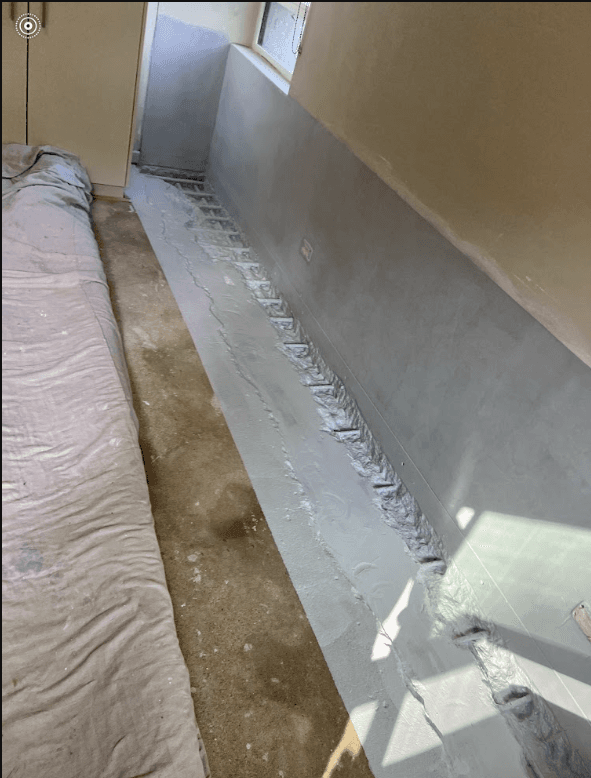 Waterproofing membrane with reinforcement at wall and floor corner