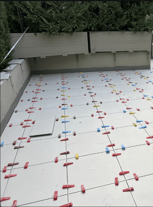 Large-format tiles being laid on waterproofed terrace in Rose Bay